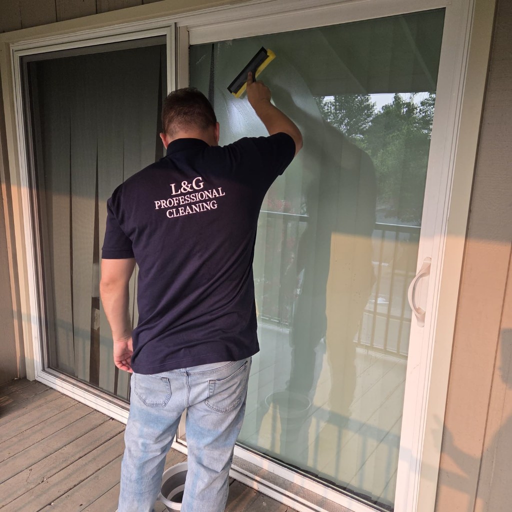 An L&G owner squeegeeing a sliding glass door