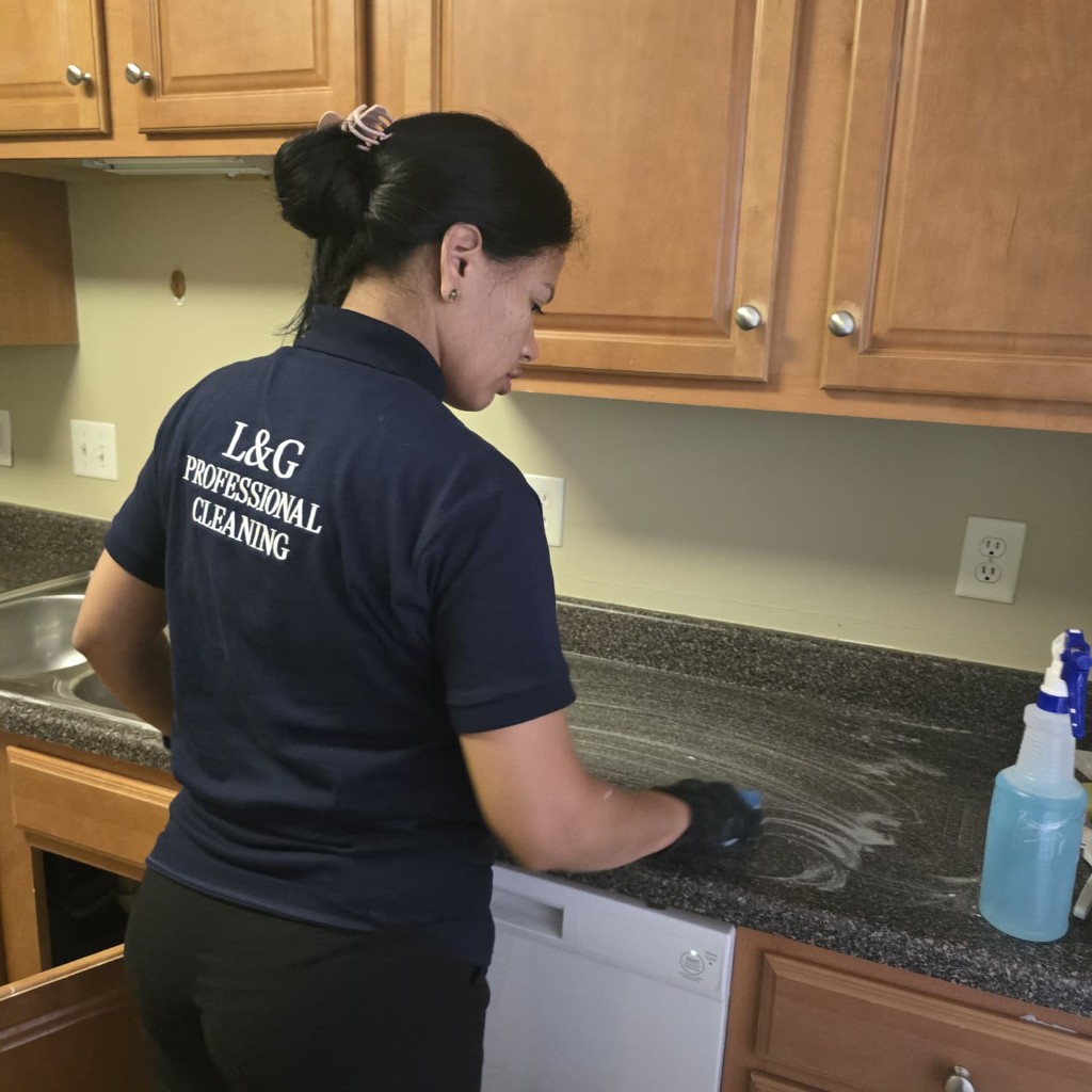 An L&G owner scrubbing a kitchen countertop